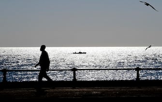 Poche le persone a passeggio, nonostante la giornata mite, sul lungomare di Napoli dove le regole impartite dalla 'Zona Rossa'  concedono solo pochi momenti all'aria aperta, 18 novembre  2020.
ANSA / CIRO FUSCO