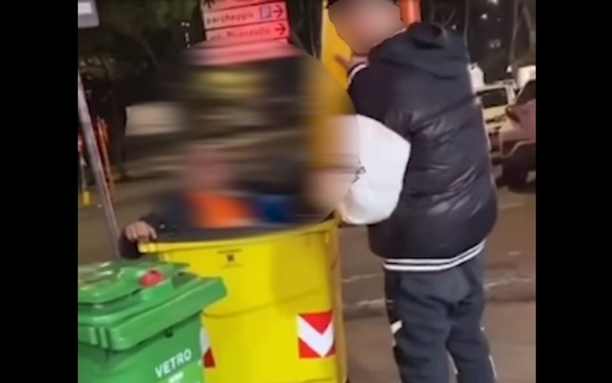 Un'immagine del video in cui l'uomo viene fatto entrare in un cassonetto