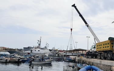 La demolizione e rimozione di 160 piccole imbarcazioni ormeggiate (affondate o semi affondate) nello specchio d'acqua dinanzi al molo Favarolo a Lampedusa, 3 settembre 2020.
.ANSA/Elio Desiderio
