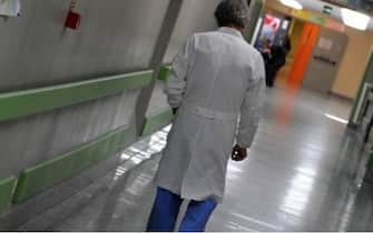 Un medico cammina nella corsia di un ospedale