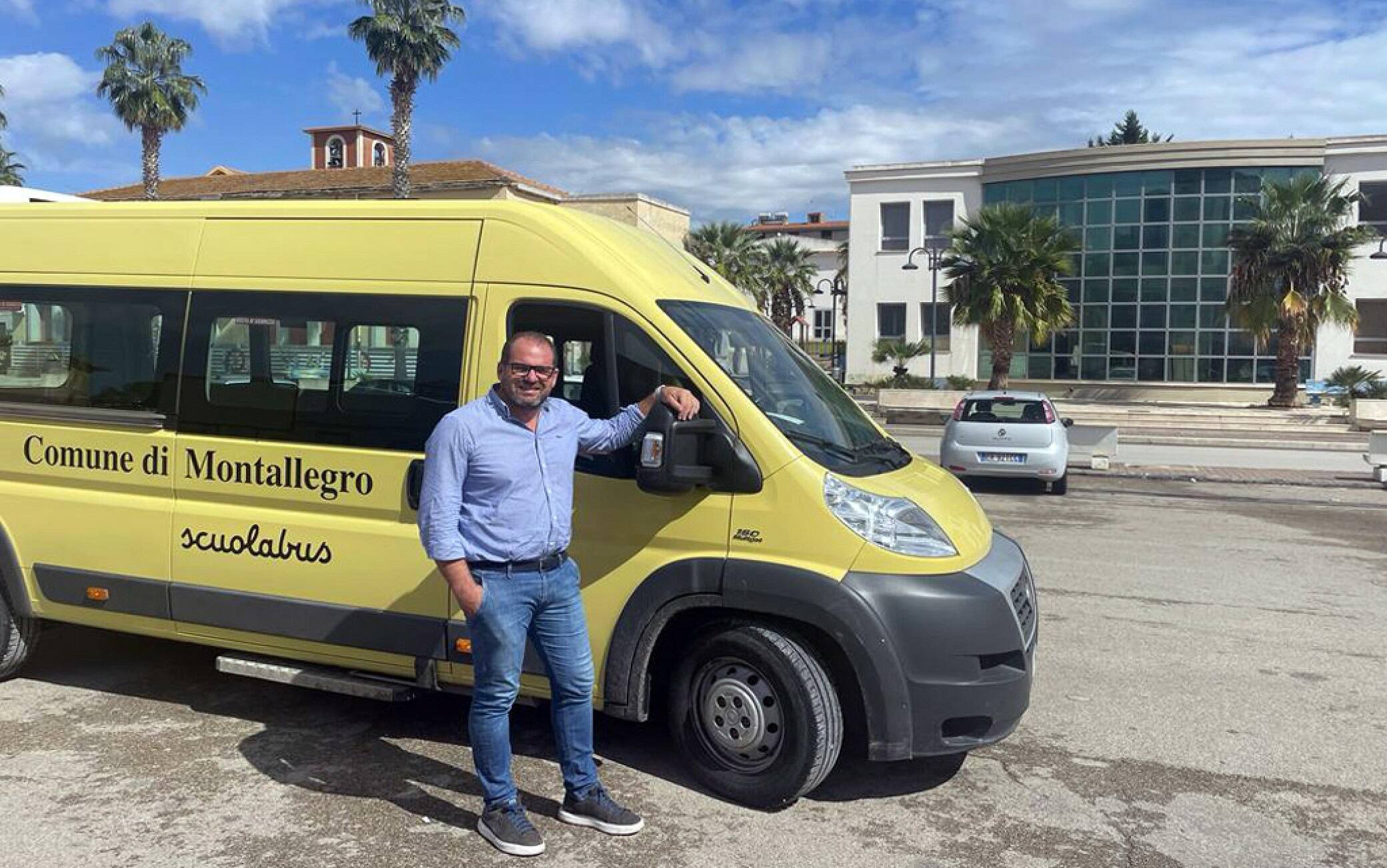 Giovanni Cirillo, sindaco di Montallegro (Agrigento), posa davanti allo scuolabus che guida in mancanza dell'autista per il servizio scuolabus, 10 ottobre 2022. ANSA/ CONCETTA RIZZO