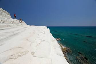 Tourists on the white marl cliffs of the Scala dei Turchi, near Realmonte, Sicily, Italy.