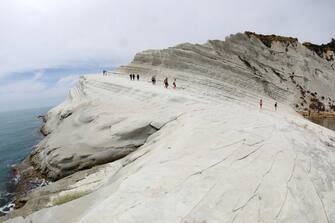 998436910 PORTO EMPEDOCLE,SICILY,ITALY - JUNE 6: A view of Scala Dei Turchi (Stair of the Turks) on June 06, 2018 in Scala Dei Turchi near Porto Empedocle, Italy. The Scala Dei Turchi is a rocky cliff on the coast of Realmonte in Sicily, Italy. Between two sandy beaches, and is accessed through a limestone rock formation in the shape of a staircase. The Scala is formed by marl, a white coloured sedimentary rock. (Photo by Franco Origlia/Getty Images)