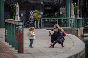 Genitori e figli bambini a passeggio sulla Darsena durante il lockdown per l emergenza epidemia coronavirus Covid-19, Milano, 26 aprile 2020.  Ansa/Matteo Corner