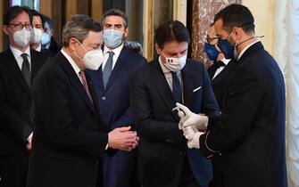Italy's new Prime Minister Mario Draghi (L) and outgoing Prime Minister Giuseppe Conte, have their hands sanitized before the handover ceremony at Chigi Palace in Rome, Italy, 13 February 2021.   ANSA/ ETTORE FERRARI/pool





