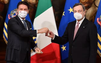 epa09009078 Italy's new Prime Minister Mario Draghi (R) receives a small bell by outgoing prime minister Giuseppe Conte (L) to mark the government handover and to open the first Council of Ministers at Chigi Palace in Rome, Italy, 13 February 2021. Former European Central Bank (ECB) chief Mario Draghi has been sworn in on the day as Italy's prime minister after he put together a government securing broad support across political parties following the previous coalition's collapse.  EPA/ETTORE FERRARI / POOL