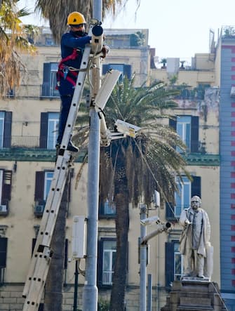Un operaio impegnato nell'installazione di telecamere di sicurezza in piazza Vittoria a Napoli
