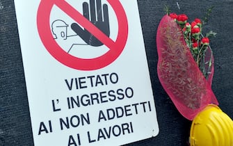 Fiori davanti a un cantiere di lavoro Fiori in ricordo di una vittima di un incidente sul lavoro
