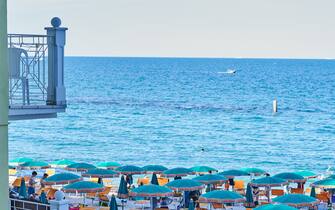 1234460792 03 August 2021, Italy, Sirollo: The beach on the Italian coast near Sirollo, which belongs to the province of Ancona in the Marche region, is full of sunshades and bathers. Photo: Annette Riedl/dpa (Photo by Annette Riedl/picture alliance via Getty Images)