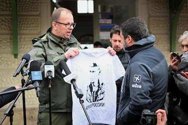 epa09809951 Mayor of Przemysl Wojciech Bakun shows a t-shirt with Putin's Portrait and slogan 'Russian Army' during a press conference with Former Deputy Prime Minister of Italy, and Lega leader Matteo Salvini (R) in front of the Main Railway Station in Przemysl, Poland 08 March 2022. Mayor Bakun unsuccessfully tried to hand Matteo Salvini a T-shirt with an image of Vladimir Putin, similar to one Salvini was posing with at Kremlin during a visit to Moscow and asked the italian senator to wear it during a visit to refugees reception center close to the border with Ukraine.  EPA/DAREK DELMANOWICZ POLAND OUT