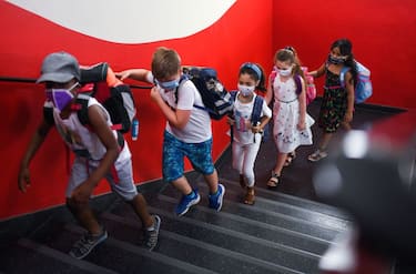 TOPSHOT - Students with face masks go upstairs to their classrooms at the Petri primary school in Dortmund, western Germany, on August 12, 2020, amid the novel coronavirus COVID-19 pandemic. - Schools in the western federal state of North Rhine-Westphalia re-started under strict health guidelines after the summer holidays. (Photo by Ina FASSBENDER / AFP) (Photo by INA FASSBENDER/AFP via Getty Images)