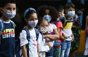 Students with face masks line up on the schoolyard of the Petri primary school in Dortmund, western Germany, on August 12, 2020, amid the novel coronavirus COVID-19 pandemic. - Schools in the western federal state of North Rhine-Westphalia re-started under strict health guidelines after the summer holidays. (Photo by Ina FASSBENDER / AFP) (Photo by INA FASSBENDER/AFP via Getty Images)
