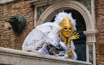 VENICE, VENETO, ITALY - 2019/03/04: A feminine masked person in a beautiful creative costume, posing on a bridge in front of a house facade, celebrating the Venetian Carnival. (Photo by Frank Bienewald/LightRocket via Getty Images)