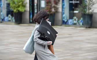 A woman carries a computer monitor for teleworking, in Nantes, western France, on March 17, 2020 while a strict lockdown comes into effect to stop the spread of the COVID-19 in the country. - A strict lockdown requiring most people in France to remain at home came into effect at midday on March 17, 2020, prohibiting all but essential outings in a bid to curb the coronavirus spread. The government has said tens of thousands of police will be patrolling streets and issuing fines of 38 to 135 euros ($42-$150) for people without a written declaration justifying their reasons for being out. (Photo by Sebastien SALOM-GOMIS / AFP) (Photo by SEBASTIEN SALOM-GOMIS/AFP via Getty Images)