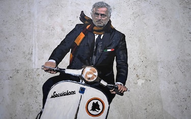 A pedestrian takes a photo of a mural painting depicting new AS Roma coach Jose Mourinho driving a Vespa scooter, like Gregory Peck in ‘La Dolce Vita’ movie, in Rome, Italy, 07 May 2021. The mural is credited to an unidentified street artist, who is only known as 'Harry Greb'. EPA-EFE/RICCARDO ANTIMIANI