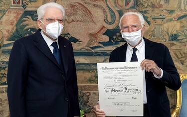 epa09604561 A handout picture made available by the Quirinal Presidential Palace (Palazzo del Quirinale) Press Office shows Italian president Sergio Mattarella (L) and Italian fashion designer Giorgio Armani (R), after Armani was awarded the title of a 'Knight of the Grand Cross' of the Order of Merit of the Italian Republic, in Rome, 26 November 2021.  EPA/PAOLO GIANDOTTI / HANDOUT  HANDOUT EDITORIAL USE ONLY/NO SALES