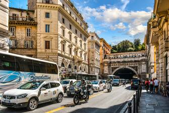 Cars, tour buses, scooters and motorcycles in mid-day traffic near the ancient city walls of Rome, Italy
