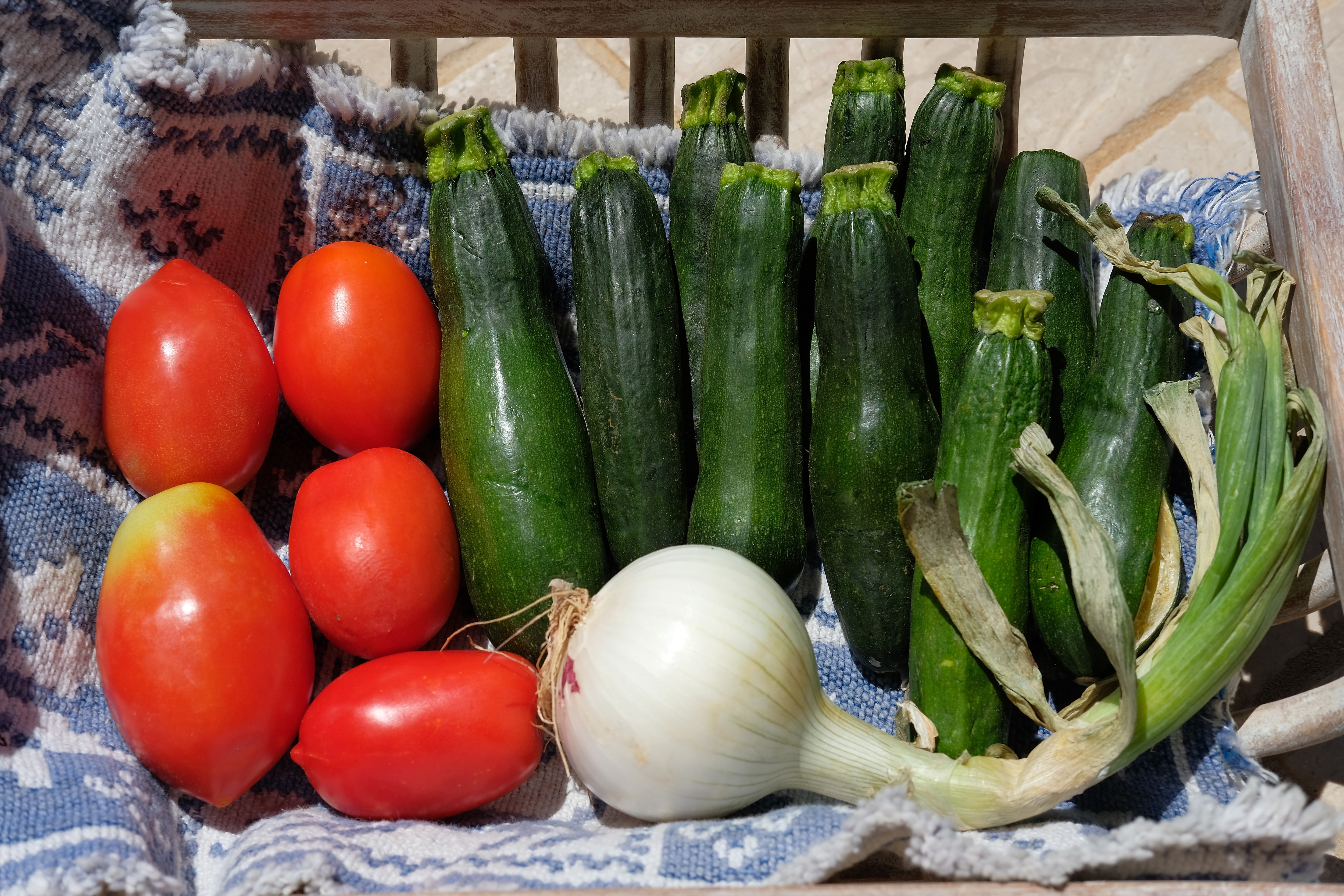 1014444562 CANNIGIONE, ITALY - JULY 29: Locally-sourced vegetables, including tomatoes, zucchini and an onion, lie in a basket on the Costa Smeralda on July 29, 2018 on the island of Sardinia near Cannigione, Italy. Sardinia is a popular summer tourist destination. (Photo by Sean Gallup/Getty Images)