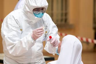 TEMPIO PAUSANIA, ITALY - MAY 21: The army doctor carries out a swab test for coronavirus (COVID-19)  on a nun inside the health facility on May 21, 2020 in Tempio Pausania, Italy. Italy has eased the lockdown due to the Covid-19 pandemic and many businesses are allowed to reopen after a full disinfection. (Photo by Emanuele Perrone/Getty Images)