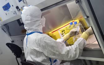 French engineer-virologist Thomas Mollet divides a 40ml flask, infected with a Sars-CoV-2 virus, under a laminar flow at the Biosafety level 3 laboratory (BSL3) of the Valneva SE Group headquarters in Saint-Herblain, near Nantes, western France, on July 30, 2020. - Could the Covid-19 vaccine be found by a biotechnology company in western France, far from major global research centers? The hypothesis is more than plausible for the British government, which has just signed an important agreement with it. (Photo by JEAN-FRANCOIS MONIER / AFP) (Photo by JEAN-FRANCOIS MONIER/AFP via Getty Images)