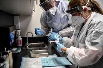 Yaquelin De La Cruz (R) and  Hari Leon Joseph (L) prepare a COVID-19 vaccine for vaccination at the Research Centers of America in Hollywood, Florida, on August 13, 2020. (Photo by CHANDAN KHANNA / AFP) (Photo by CHANDAN KHANNA/AFP via Getty Images)