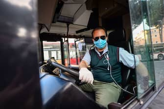 1222091943 ROME, ITALY - APRIL 30: A man wearing a protective mask drives a public bus in Piazza Venezia area empty of tourists during the Coronavirus (COVID-19) pandemic, on April 30, 2020 in Rome, Italy. Italy will remain on lockdown to stem the transmission of the Coronavirus (Covid-19), slowly easing restrictions. (Photo by Silvia Lore/Getty Images)