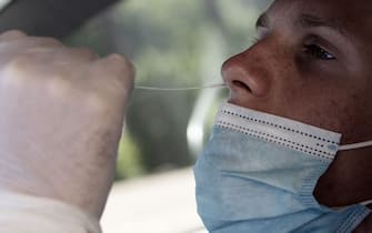 A man undergoes a swab test for coronavirus at a drive-through testing site of the Santa Maria della Pieta hospital in Rome on August 18, 2020. - On August 16, Italy suspended its discos and ordered the mandatory wearing of masks from 6:00pm (1600 GMT) to 6:00am to clamp down on the spread of infection among young people, less than a month before the restart of school. (Photo by Tiziana FABI / AFP) (Photo by TIZIANA FABI/AFP via Getty Images)