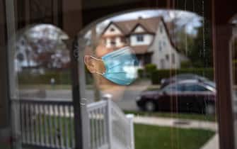 LONG ISLAND, NEW YORK - APRIL 16: Salvadorian immigrant Ledis, quarantined at home with COVID-19, looks from her front door on April 16, 2020 in Long Island, New York. Ledis has been on lockdown with her family, all suffering from coronavirus, for the last two weeks. With little health insurance and no unemployment benefits, immigrant communities have been especially hard hit by COVIOD-19 and the economic effects of the prolonged crisis. (Photo by John Moore/Getty Images)