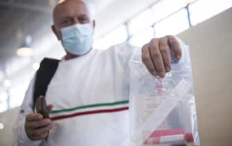 CASELLE TORINESE, ITALY - AUGUST 26: A man wearing protective mask shows a personal swabs test kit on August 26, 2020 in Turin, Italy. At Italian airports, all travelers from countries at risk of Covid-19 are tested with swabs to prevent the spread of Covid 19 in Italy. (Photo by Stefano Guidi/Getty Images)