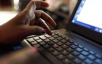 A woman uses a laptop on April 3, 2019, in Abidjan. - According to the figures of the platform of the fight against cybercrime (PLCC) of the national police, nearly one hundred crooks of the internet, were arrested in 2018 in Ivory Coast, a country known for its scammers on the web, has announced on April 2, 2019 the Ivorian authority of regulation of the telephony. (Photo by ISSOUF SANOGO / AFP)        (Photo credit should read ISSOUF SANOGO/AFP via Getty Images)