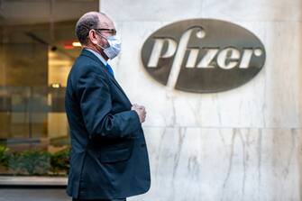NEW YORK, NY - NOVEMBER 09: People walk by the Pfizer headquarters on November 9, 2020 in New York City. Pharmaceutical company Pfizer announced positive early results on its COVID-19 vaccine trial and has proven to be 90% effective in preventing infection of the virus. (Photo by David Dee Delgado/Getty Images)