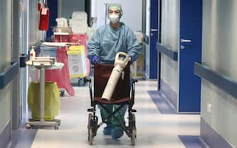 Un'infermiera porta una bombola di ossigeno, in un corridoio della terapia intesiva in funzione da domani per i pazienti con  il coronavirus,  presso l'isituto ospedaliero Fondazione Poliambulanza, Brescia 16 marzo 2020. 
ANSA/FILIPPO VENEZIA