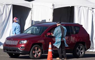 epa08837772 A person in a vehicle is tested with a swab at a drive-thru COVID-19 testing site operated by the District of Columbia, in Washington, DC, USA, 23 November 2020. As Thanksgiving approaches the coronavirus COVID-19 pandemic shows no signs of slowing in the United States. Record daily cases and hospitalizations are straining the health care system.  EPA/MICHAEL REYNOLDS