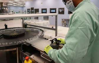 1228456459 A laboratory technicians handles vials as part of filling and packaging tests for the large-scale production and supply of the University of Oxfords COVID-19 vaccine candidate, AZD1222, conducted on a high-performance aseptic vial filling line on September 11, 2020 at the Italian biologics manufacturing facility of multinational corporation Catalent in Anagni, southeast of Rome, during the COVID-19 infection, caused by the novel coronavirus. - Catalent Biologics manufacturing facility in Anagni, Italy will serve as the launch facility for the large-scale production and supply of the University of Oxfords Covid-19 vaccine candidate, AZD1222, providing large-scale vial filling and packaging to British-Swedish multinational pharmaceutical and biopharmaceutical company AstraZeneca. (Photo by Vincenzo PINTO / AFP) (Photo by VINCENZO PINTO/AFP via Getty Images)