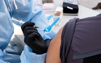 epa08890935 Zita Konik administers the Pfizer-BioNTech coronavirus disease (COVID-19) vaccine to Aegan Bayongan a staff member at the Redwoods, a skilled nursing facility in Mill Valley, California, USA, 17 December 2020.  EPA/DAVID ODISHO