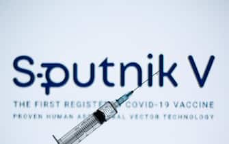 In this photo illustration a medical syringe seen displayed in front of the Sputnik V logo. (Photo by Thiago Prudêncio / SOPA Images/Sipa USA)