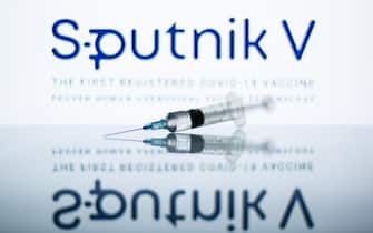 In this photo illustration a medical syringe seen displayed in front of the Sputnik V logo. (Photo by Thiago Prudêncio / SOPA Images/Sipa USA)