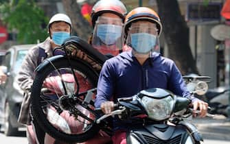 epa09236387 Motorists wear face masks in Hanoi, Vietnam, 30 May 2021. Vietnam has recently detected a new coronavirus variant which combines the Indian and UK COVID-19 variants, according to Vietnamese Health Minister Nguyen Thanh Long.  EPA/LUONG THAI LINH