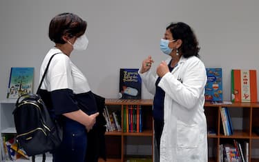 La dottoressa Antonietta Spadea, direttore UOC accoglienza, tutela e promozione della salute, illustra ad una donna in gravidanza illustra il progetto "Leggimi presto: il dono del libro ad una donna in gravidanza", presso il consultorio familiare di Primavalle della Asl Roma 1, Roma, 11 maggio 2021. ANSA/RICCARDO ANTIMIANI