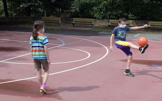 Due bambini giocano a calcio in un centro estivo