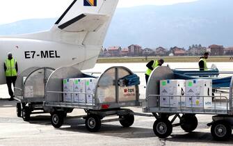 epa09096006 The workers at Sarajevo Airport carry the first 23,400 doses of Biontech/Pfizer vaccine, which Bosnia and Herzegovina purchased under the COVAX mechanism, in Sarajevo, Bosnia and Herzegovina, 25 March 2021.The Bosnian government introduced restrictive measures, a curfew at night and the closure of restaurants, during the worsening coronavirus pandemic in Bosnia and Herzegovina.  EPA/FEHIM DEMIR