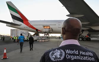 epa09425926 An official (R) from the World Health Organization (WHO) looks on as some of the 880,460 doses of Moderna Covid-19 vaccines (L) are offloaded upon their arrival at the Jomo Kenyatta International Airport (JKIA) in Nairobi, Kenya, 23 August 2021. The vaccines are the first shipment of 1.76 million doses donated to Kenya by the United States via COVAX facility. Kenya continues to receive more vaccine donations from different countries and organizations as it tries to contain the current fourth wave of infections being driven by the contagious Delta variant.  EPA/Daniel Irungu