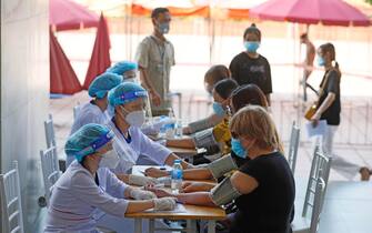 epa09459478 People have their health checked before they receive a shot of AstraZeneca (Vaxzevria) vaccine against COVID-19 in Hanoi, Vietnam, 10 September 2021. Vietnam is ramping up the pace of its vaccination drive, as part of an effort to combat the spread of the COVID-19 coronavirus.  EPA/LUONG THAI LINH
