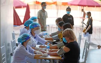 epa09459478 People have their health checked before they receive a shot of AstraZeneca (Vaxzevria) vaccine against COVID-19 in Hanoi, Vietnam, 10 September 2021. Vietnam is ramping up the pace of its vaccination drive, as part of an effort to combat the spread of the COVID-19 coronavirus.  EPA/LUONG THAI LINH