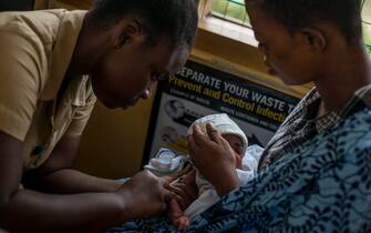 A baby receives vaccine by a nurse at the maternity ward of the Ewin Polyclinic in Cape Coast, Ghana, on April 30, 2019. - Ewim Polyclinic on April 30, 2019 was the first in Ghana to roll out the Malaria vaccine Mosquirix. After Malawi, Ghana is the second country to launch the vaccine. Known by its lab initials as RTS,S but branded Mosquirix, the vaccine has passed lengthy scientific trials, which found it to be safe and reduced the risk of Malaria by nearly 40 percent -- the best-ever recorded. It was approved by European regulators in 2015. (Photo by CRISTINA ALDEHUELA / AFP) (Photo by CRISTINA ALDEHUELA/AFP via Getty Images)