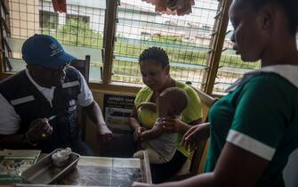 A World Health Organisation (WHO) doctor administers a vaccine to a child at Ewin Polyclinic in Cape Coast on April 30, 2019. - Ewim Polyclinic became the first in Ghana to roll out the Malaria vaccine Mosquirix. After Malawi, Ghana is the second country to launch the vaccine. Known by its lab initials as RTS,S but branded Mosquirix, the vaccine has passed lengthy scientific trials, which found it to be safe and reduced the risk of Malaria by nearly 40 percent. (Photo by CRISTINA ALDEHUELA / AFP)        (Photo credit should read CRISTINA ALDEHUELA/AFP via Getty Images)