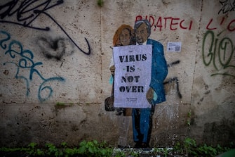 ROME, ITALY - DECEMBER 03: A mural by street artist TVBOY depicts the two Italian virologists Roberto Burioni and Ilaria Capua with a banner reading "Virus is not over", on a wall in the historic center of Rome, during the Coronavirus pandemic, on December 1, 2020 in Rome, Italy. (Photo by Antonio Masiello/Getty Images)