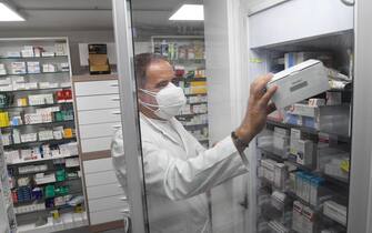 Un farmacista prende dal frigorifero una scatola che continene le dosi di Pfizer in una farmacia di Milano, 10 novembre 2021. ANSA/DANIEL DAL ZENNARO