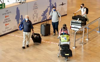 Passengers walk with their luggage upon their arrival at Ben Gurion Airport near Lod on November 1, 2021, as Israel reopens to tourists vaccinated against Covid-19. (Photo by JACK GUEZ / AFP) (Photo by JACK GUEZ/AFP via Getty Images)