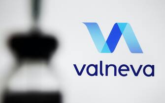In this photo illustration a Valneva logo is seen in front of a vial and a medical syringe. (Photo by Pavlo Gonchar / SOPA Images/Sipa USA)